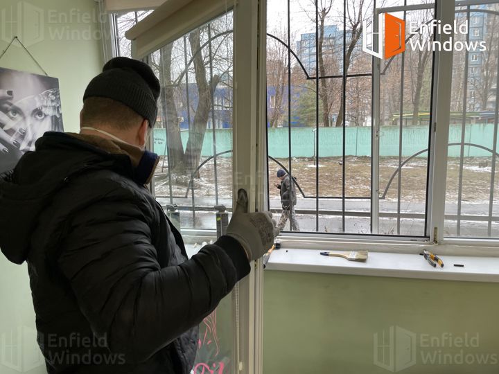 мастер ремонтирует пластиковое окно
